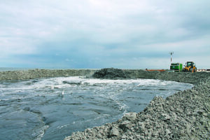 Strandaufspülung: Unter hohem Druck wird das Sand-Wasser-Gemisch in das abgeteilte Spülfeld gepumpt. 